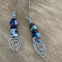 two necklaces with different designs on them sitting on a table