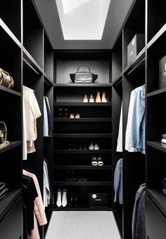 a walk - in closet with black shelving and white carpeted flooring is shown