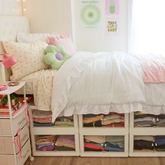 a white bed with lots of drawers underneath it