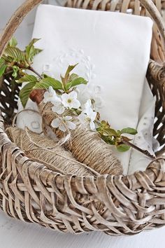 a wicker basket filled with white linens and flowers