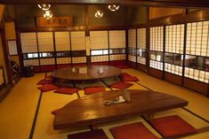 a room with tables and rugs on the floor