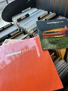 an orange album sitting on top of a pile of records