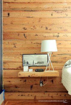 a bed room with a neatly made bed and wooden walls