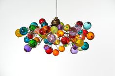 a multicolored chandelier hanging from a ceiling in the shape of balls