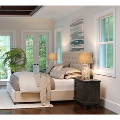 a bedroom with white walls and wood floors