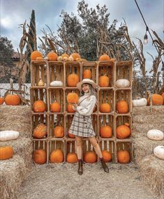 a woman standing in front of a display of pumpkins