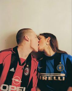 a man and woman kissing each other on the cheek