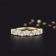 a gold and white diamond ring on a black surface