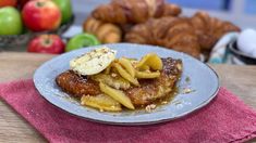 a blue plate topped with food next to croissants