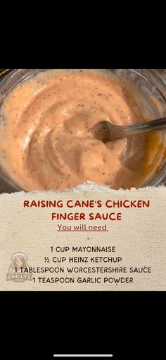 a jar filled with sauce sitting on top of a table next to a sign that says raising cane's chicken finger sauce