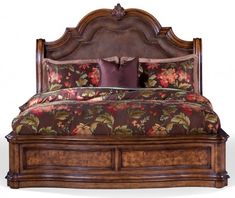 a bed that has flowers on it with pillows and pillow cases around the headboard