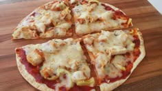 four slices of pizza sitting on top of a wooden cutting board