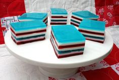 several pieces of cake sitting on top of a white plate with red and blue frosting