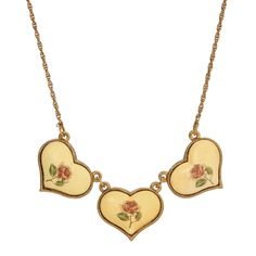 three heart shaped pendants with roses on them are hanging from a gold plated chain