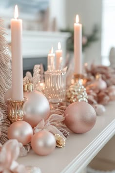 a table topped with candles and ornaments on top of a white mantle covered in christmas decorations