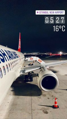 an airplane sitting on the tarmac at night