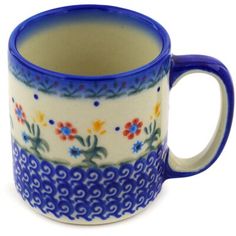 a blue and white coffee cup with flowers on the inside, sitting in front of a white background