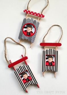 three pictures hanging from clothes pins on a white surface with red and black striped paper