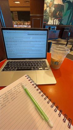 an open laptop computer sitting on top of a desk next to a cup of coffee