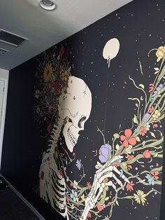 a large mural on the side of a building with a skeleton and flowers painted on it