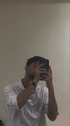 a man taking a selfie in front of a mirror with his cell phone up to his face