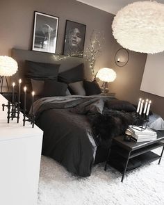 a black and white bedroom with candles on the bed