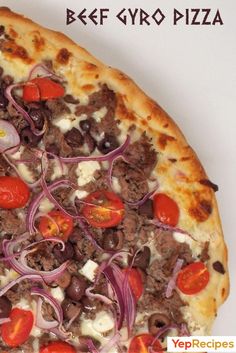 a close up of a pizza on a plate with onions and tomatoes in the middle