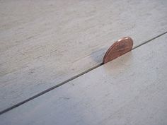 a penny sitting on top of a wooden floor