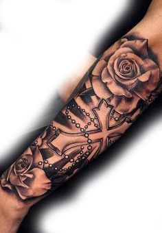 a black and white photo of a rose with cross tattoos on it's arm