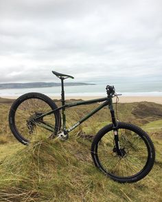 a mountain bike sitting on top of a grass covered hill