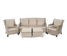 an outdoor furniture set with beige cushions and matching foot stools, including a coffee table