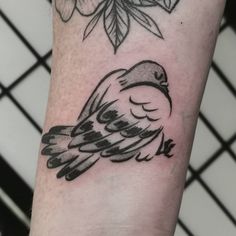 a small bird tattoo on the arm