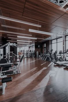 an empty gym with lots of machines and windows overlooking the cityscape is seen in this image