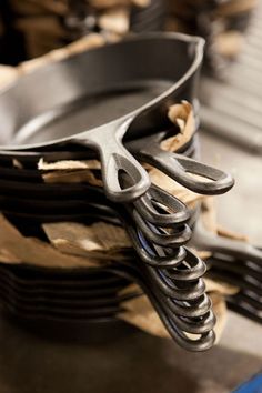 there are many forks stacked on top of each other in front of some metal pans