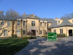 a large yellow house with a green sign in front of it that says energy star