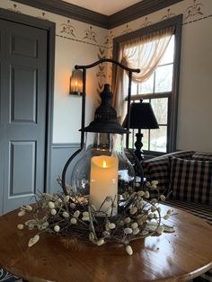 a table with a candle on top of it in front of a door and window