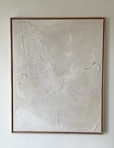 a white painting hanging on the wall