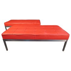 two red benches sitting next to each other on top of a white surface with black legs