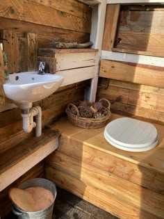 a bathroom with wooden walls and flooring next to a white sink on top of a counter