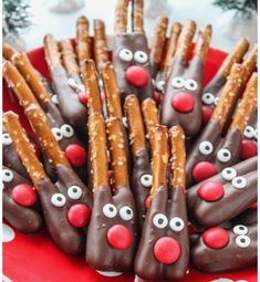 chocolate pretzels decorated with reindeer noses and eyes on a red platter for christmas