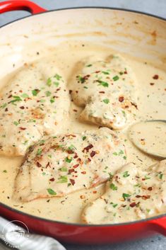 a red pan filled with chicken covered in gravy