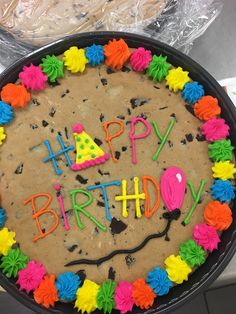 a birthday cake with the words happy birthday written on it in bright colors and frosting