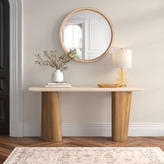 a table with a mirror on it in front of a door and a rug underneath