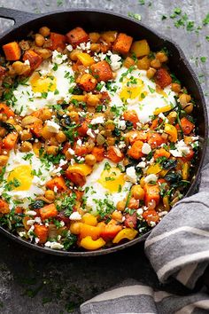 a pan filled with eggs and vegetables on top of a table