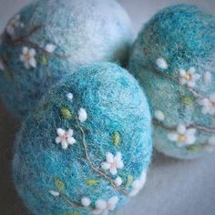 three blue balls with white flowers on them