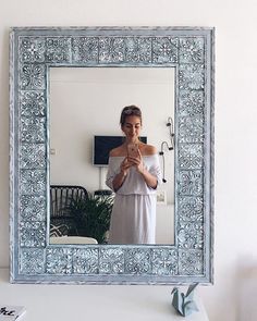 a woman taking a selfie in front of a mirror