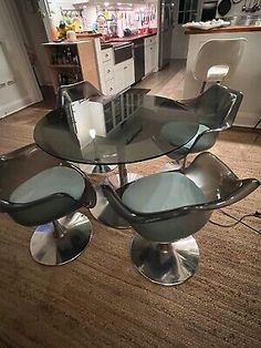 a glass table with four chairs on it