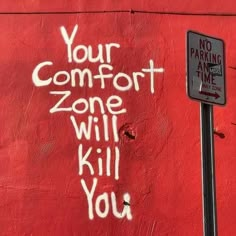 graffiti on the side of a red building reads, your comfort zone will kill you