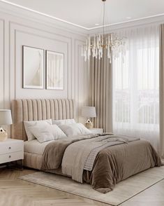 a bedroom with a bed, chandelier and two pictures hanging on the wall