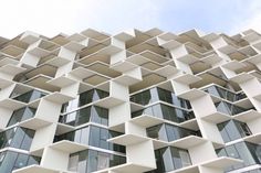 a very tall building with lots of balconies on it's sides and windows